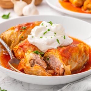 Cabbage rolls served with sour cream and dill.