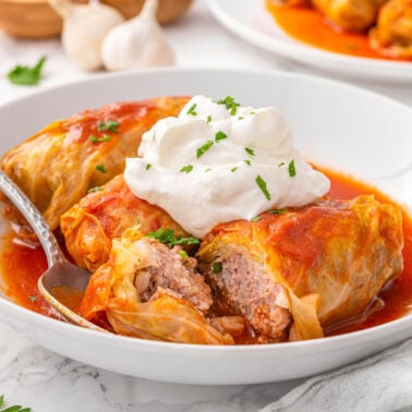 Cabbage rolls served with sour cream and dill.