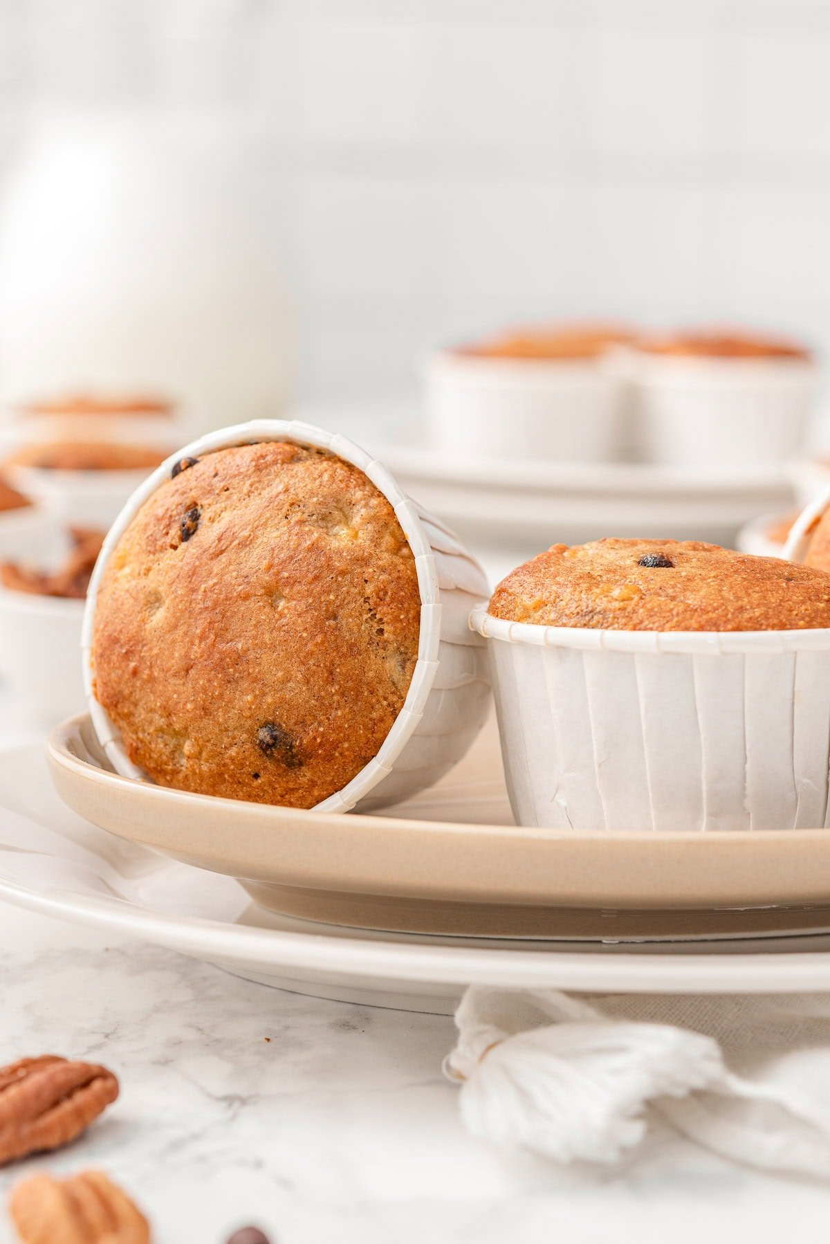 Kodiak banana muffins in wrappers on a plate.