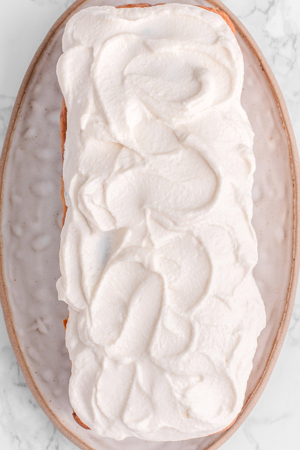 Cottage cheese pumpkin bread with frosting on a platter.