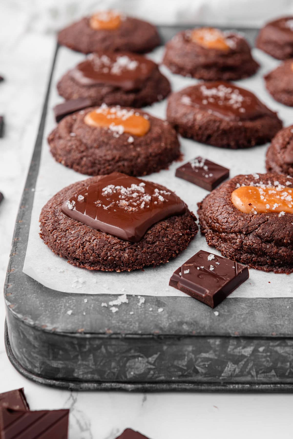 3 ingredient nutella cookies with caramel and chocolate on a baking sheet.