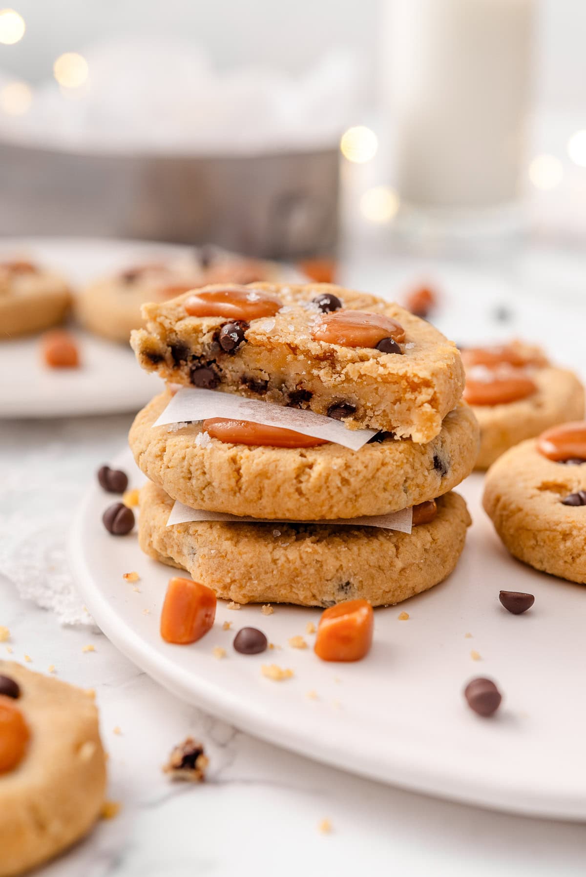 A stack of salted caramel chocolate chip chickpea cookies one showing texture inside.