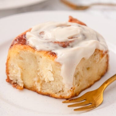 Greek yogurt cinnamon roll on a plate with fork.