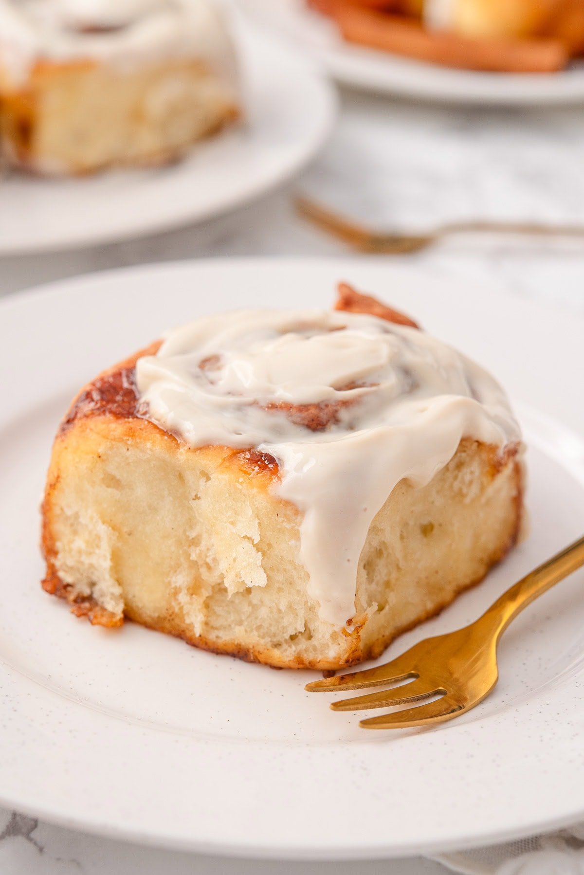 Greek yogurt cinnamon roll on a plate with fork.