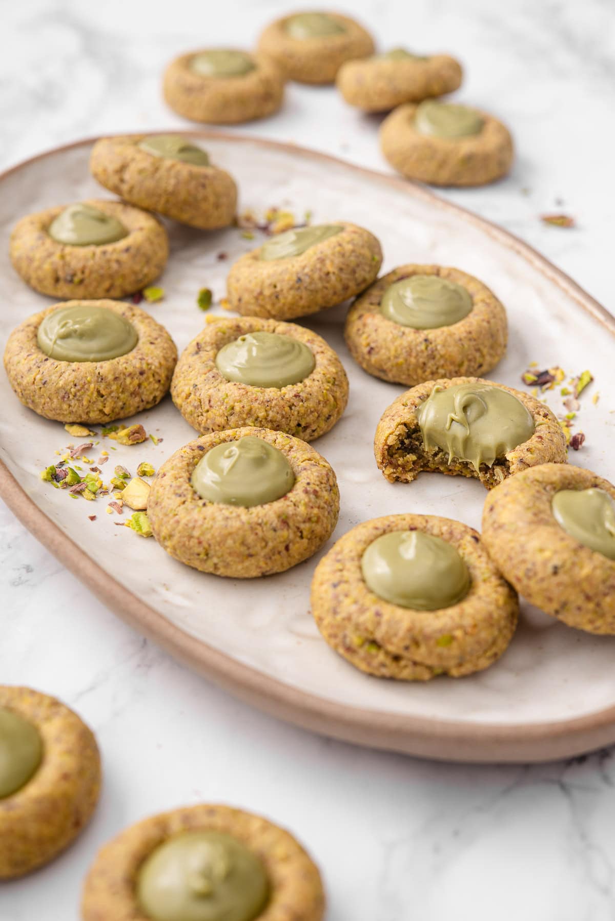 Pistachio thumbprint cookies on a platter.