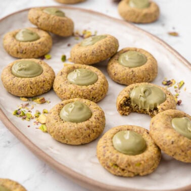 Pistachio thumbprint cookies on a platter.