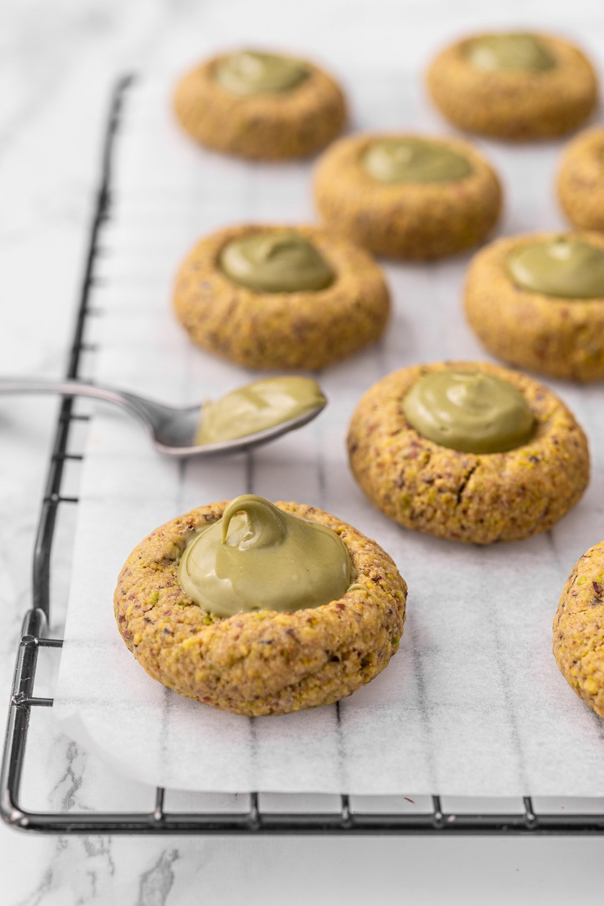 Closeup of pistachio thumbprint cookies.