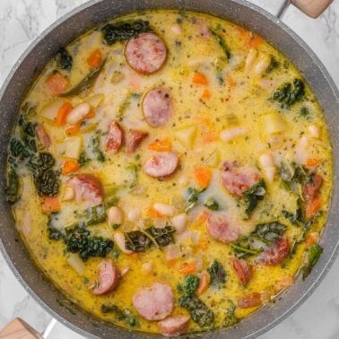 Sausage kale white bean soup in a pot.