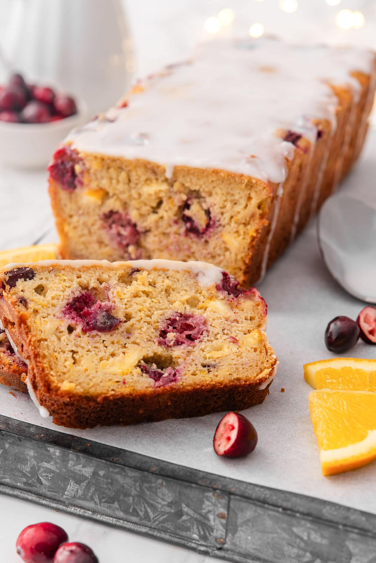 Cranberry orange bread with glaze on a platter.