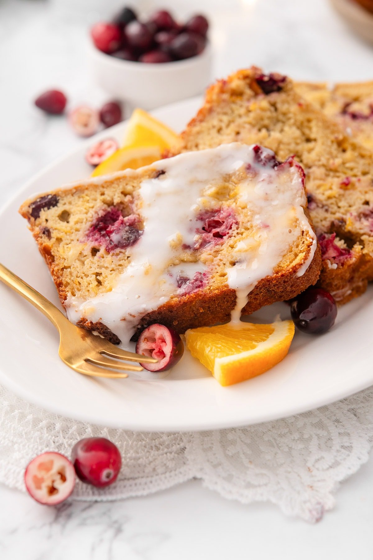 Sliced cranberry orange bread with glaze.