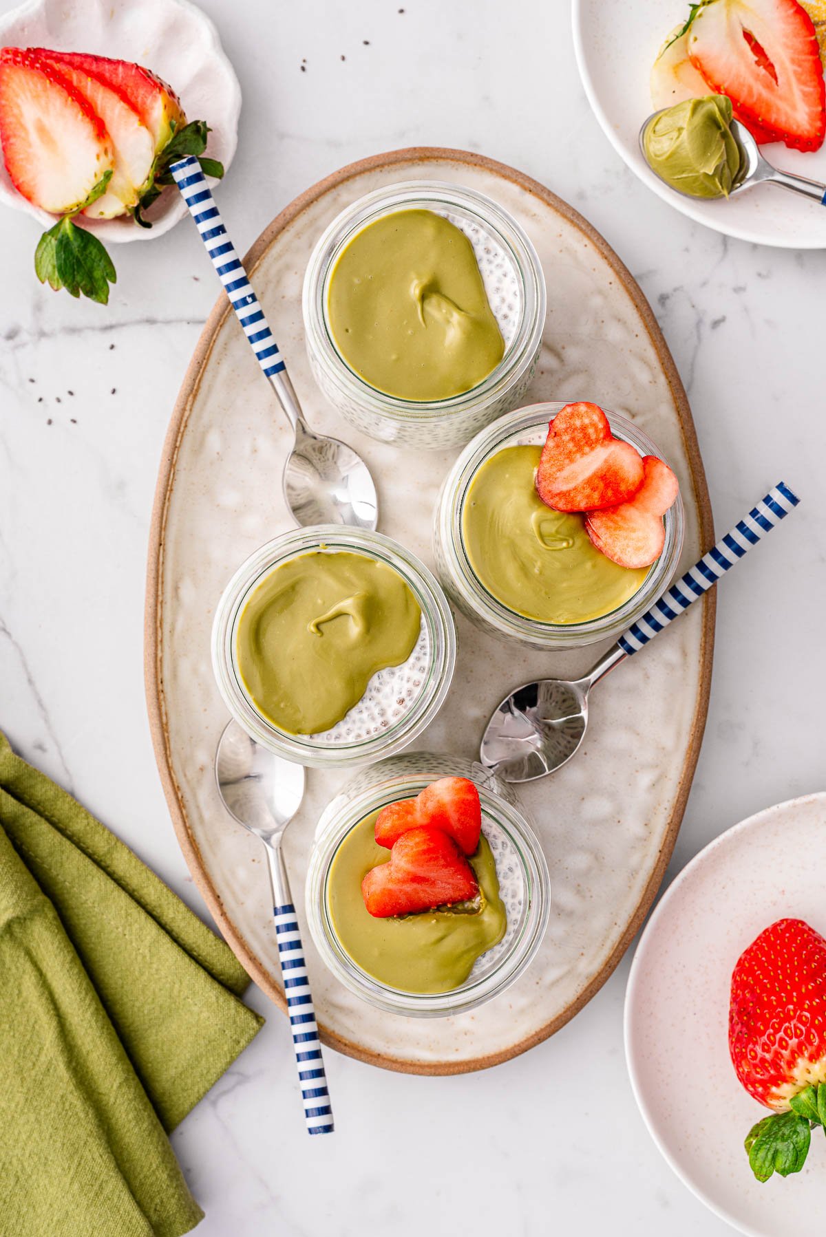 Looking down on four jars with Greek yogurt chia pudding with toppings.