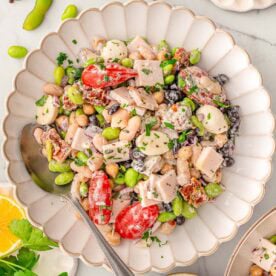 Dense bean salad in a serving dish with spoon.
