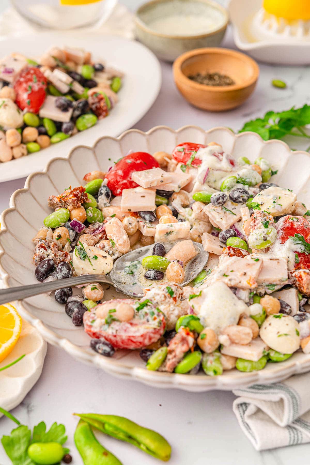 Side view of dense bean salad in a serving bowl with spoon.
