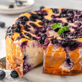 Blueberry yogurt cake sliced and one slice pulled out with serving utensil.