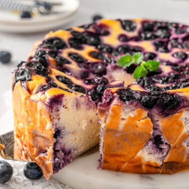 Blueberry yogurt cake sliced and one slice pulled out with serving utensil.