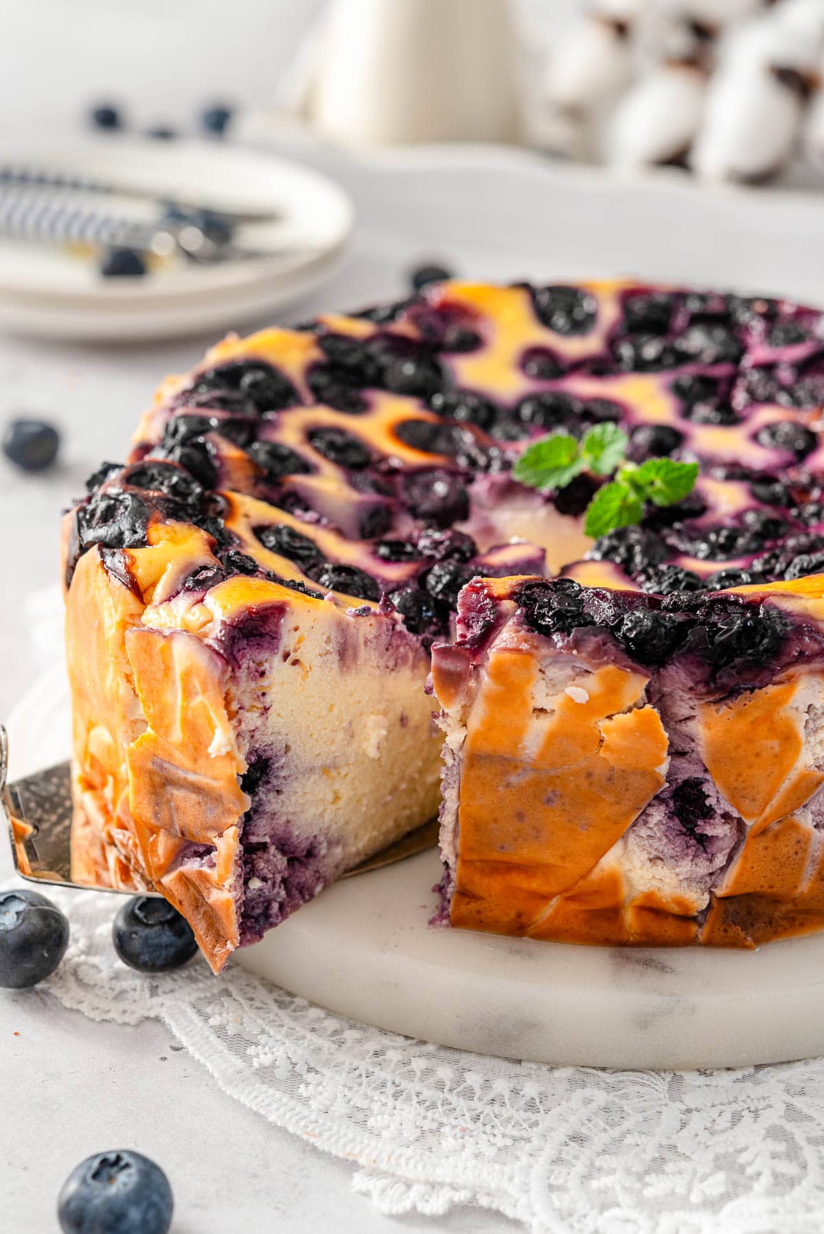 Blueberry yogurt cake sliced and one slice pulled out with serving utensil.