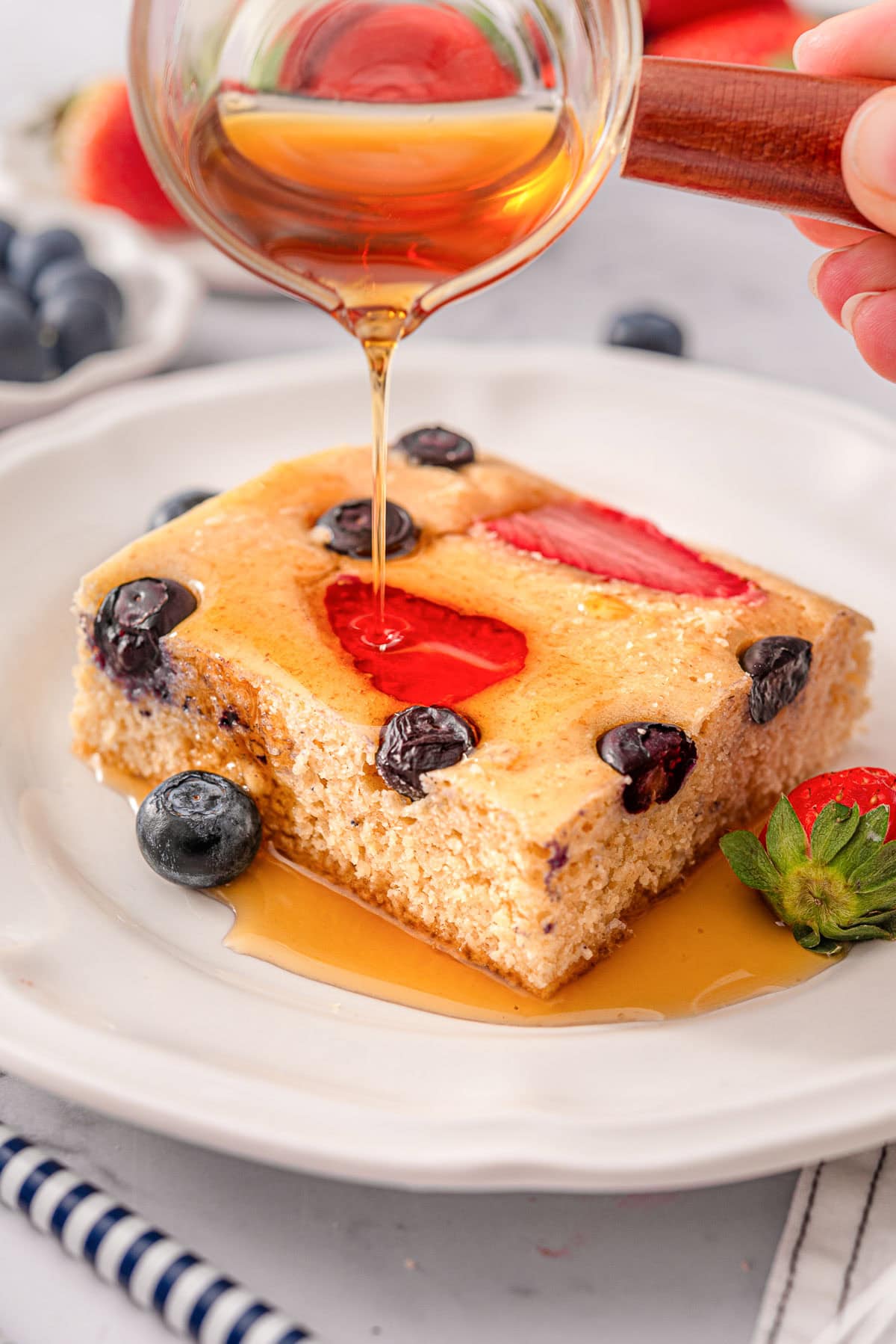 One kodiak sheet pan pancake with syrup on a plate.