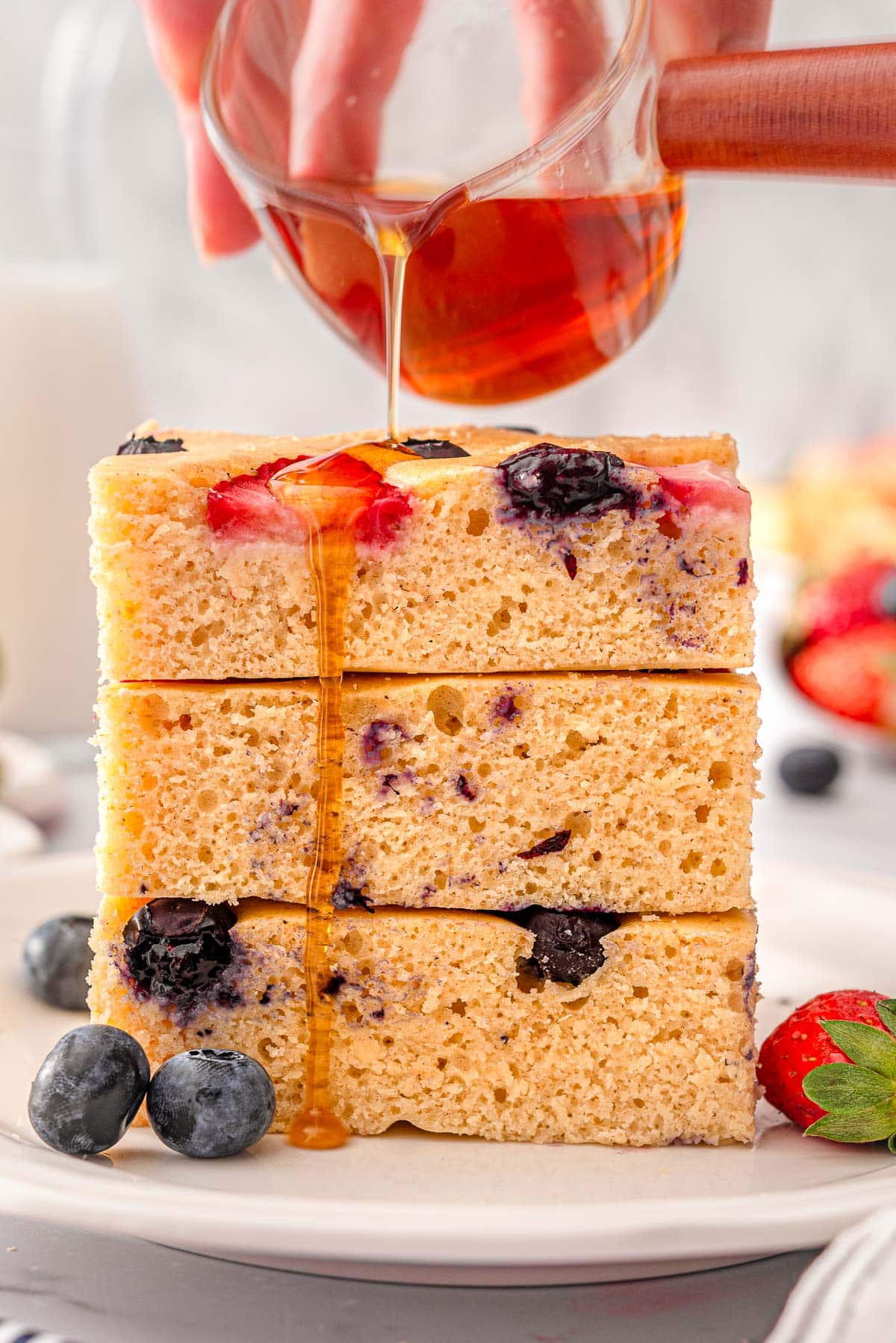 A stack of kodiak sheet pan pancakes drizzled with syrup.