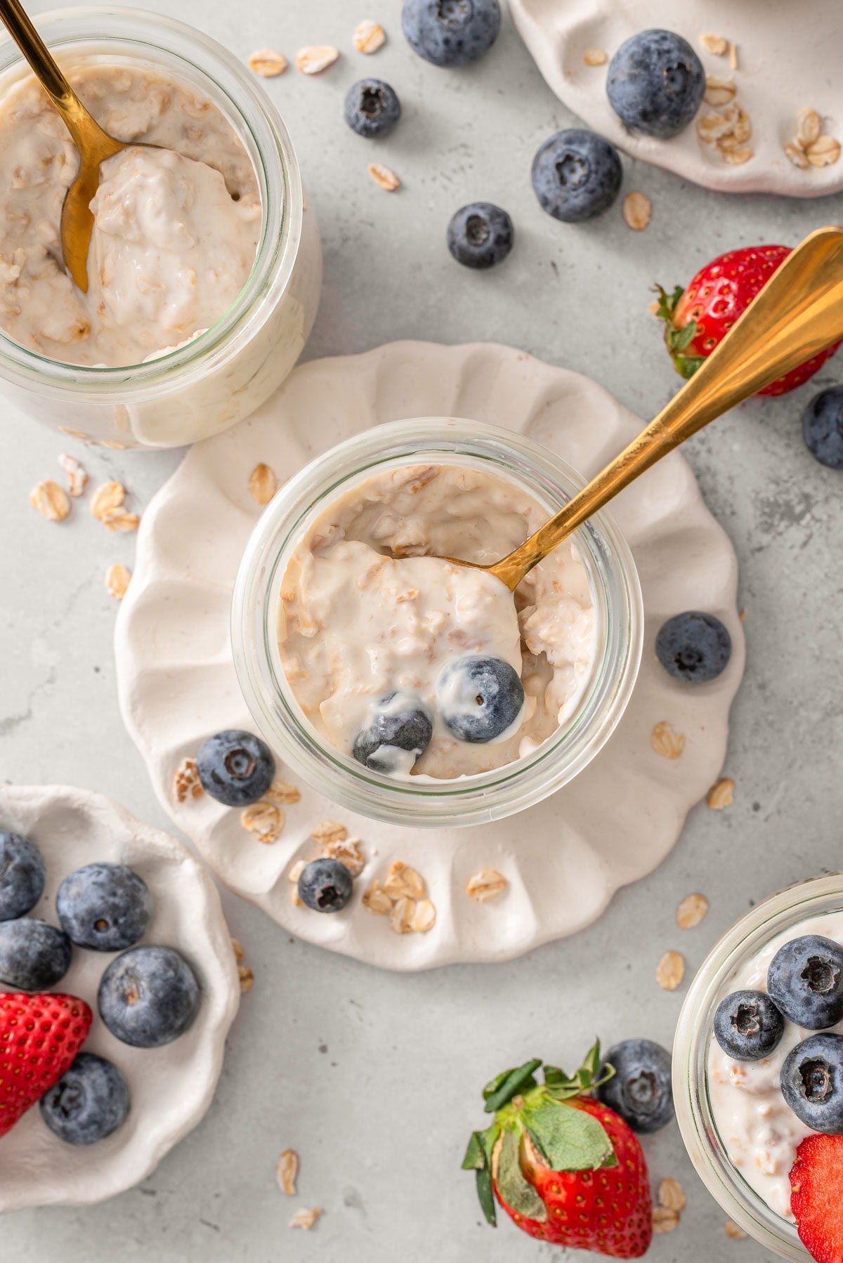 Looking down on jars with greek yogurt overnight oats and spoons in them.