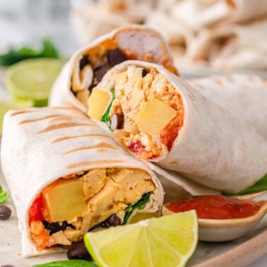 Sheet pan breakfast burritos cut in half and served on a platter.