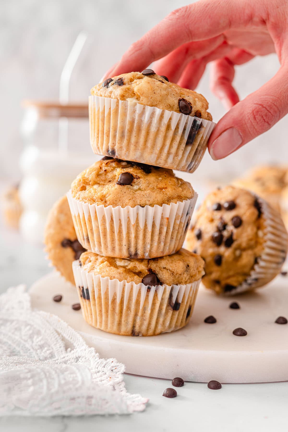 Person stacking 3 cottage cheese banana muffins on top of each other.