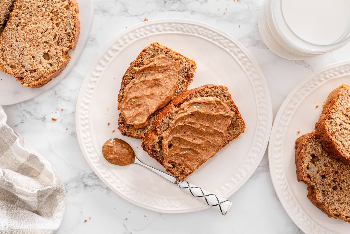 Slices of healthy banana bread with peanut butter on a plate.