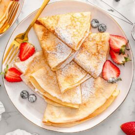 Cottage cheese crepes dusted with powdered sugar served with berries.
