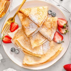 Cottage cheese crepes dusted with powdered sugar served with berries.