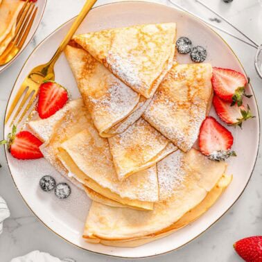 Cottage cheese crepes dusted with powdered sugar served with berries.