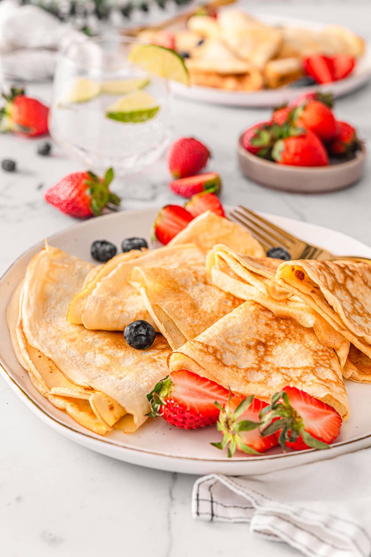 Cottage cheese crepes served on a plate with strawberries.