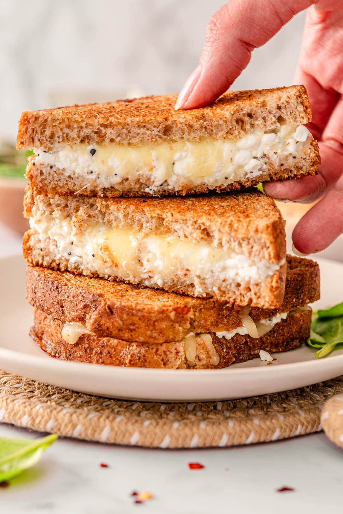 Cottage cheese grilled cheese cut in half stacked on a plate.