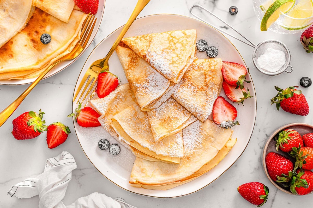 Cottage cheese crepes dusted with powdered sugar served with berries.