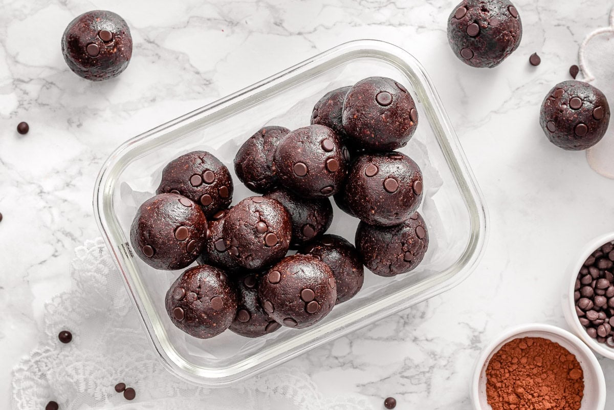 Chocolate protein balls in glass container.