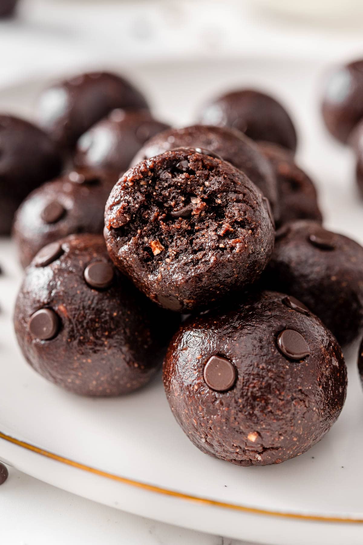 Chocolate protein balls bite taken out of showing texture inside.