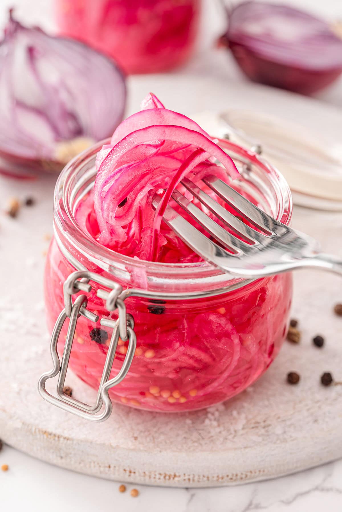 Pickled red onions on a fork.